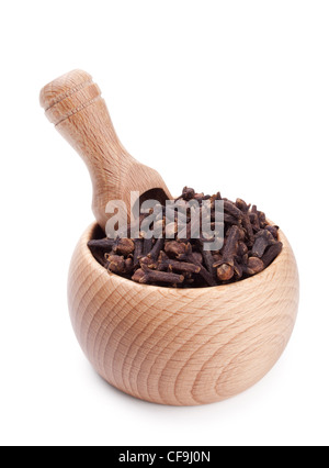 Cucchiaio di legno in un recipiente pieno di chiodi di garofano isolati su sfondo bianco Foto Stock