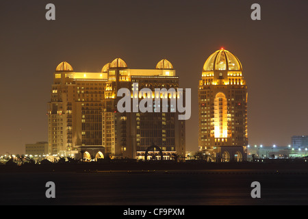 Edifici a Doha illuminata di notte, in Qatar Foto Stock