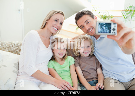 Padre prendendo foto di famiglia sul divano Foto Stock