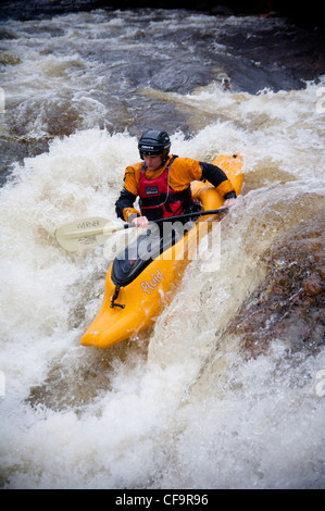 Kayak circa a goccia di whitewater cascata sul fiume nevis in inverno Foto Stock