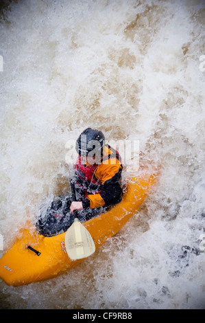 Kayak circa a goccia di whitewater cascata sul fiume nevis in inverno Foto Stock