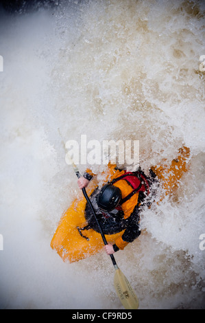 Kayak circa a goccia di whitewater cascata sul fiume nevis in inverno Foto Stock