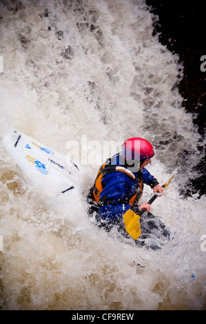 Kayak circa a goccia di whitewater cascata sul fiume nevis in inverno Foto Stock