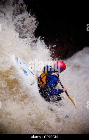 Kayak circa a goccia di whitewater cascata sul fiume nevis in inverno Foto Stock