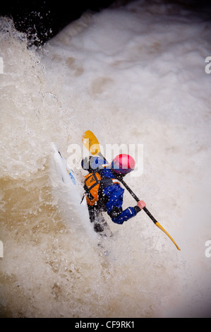 Kayak circa a goccia di whitewater cascata sul fiume nevis in inverno Foto Stock