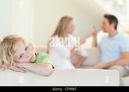 Triste ragazzo con sostenendo i genitori dietro di lui Foto Stock