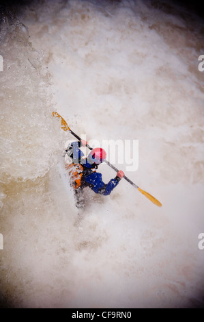 Kayak circa a goccia di whitewater cascata sul fiume nevis in inverno Foto Stock