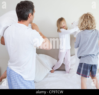 Giocoso famiglia avente un cuscino lotta Foto Stock