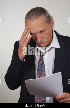 Ha sottolineato, preoccupato per il business man guardando le carte, allentata da indossare giacca e cravatta Foto Stock