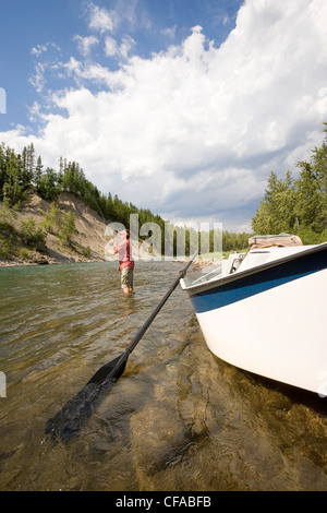 Giovane uomo di Pesca a Mosca Report di Pesca sul Fiume Elk, da un dory, Fernie, East Kootenays, British Columbia, Canada. Foto Stock