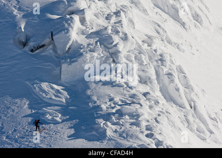 Un backcountry rider passeggiate lungo una cresta alpina in Fairy Meadows, gamma inflessibile, Selkirks, BC Foto Stock