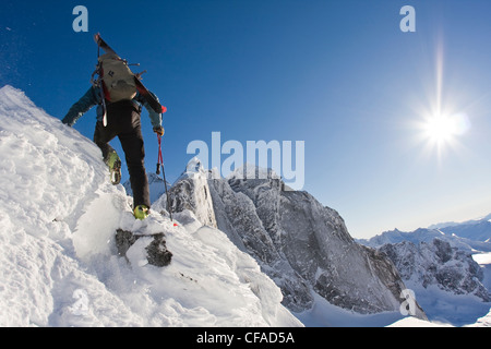 Un backcountry rider passeggiate lungo una cresta alpina in Fairy Meadows, gamma inflessibile, Selkirks, BC Foto Stock