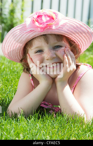 5 anno vecchia ragazza con sundress e hat posa sul prato anteriore, Canada. Foto Stock