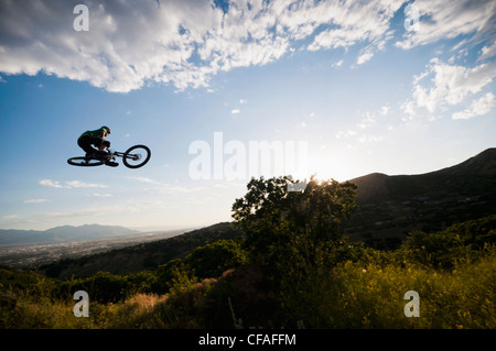 Mountain Biker saltando su pendio Foto Stock