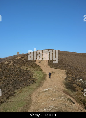 Un viandante sulle colline vicino a Sant Agnese in Cornovaglia in inverno mostra Wheal Cotes una scogliera mine building Foto Stock