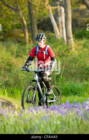 Una donna mountain bike nei pressi di Victoria, l'isola di Vancouver, British Columbia, Canada. Foto Stock