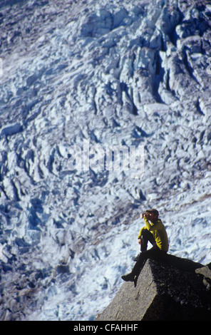 Uomo seduto sulla roccia a Bugaboos, British Columbia, Canada. Foto Stock