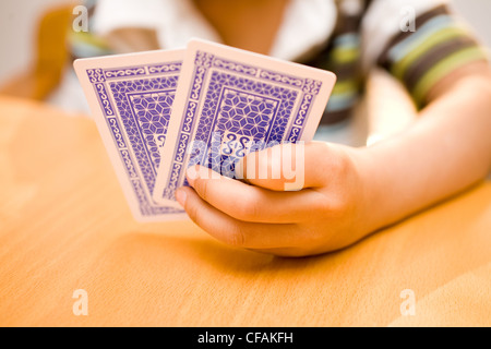 Mani tenendo le carte da gioco su un tavolo in una ricreazione e concetto di gioco d'azzardo Foto Stock