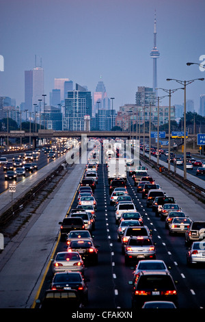 Ora di punta del traffico su QEW (Queen Elizabeth modo) e Toronto skyline della città di Toronto, Ontario, Canada. Foto Stock