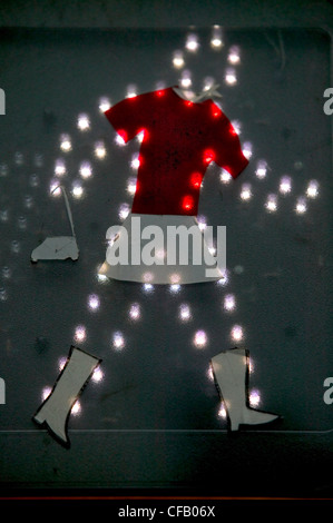 L'illuminato di uomo a piedi camminando segno decorata da artista di strada da donna con borsetta, semafori, New York City. Foto Stock