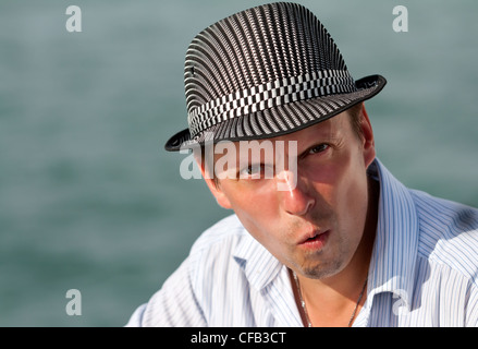 Ritratto di un uomo in un cappello stupiti lo sfondo del Mare Azure Foto Stock