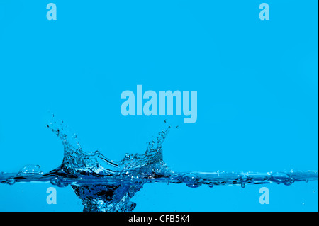 Gli spruzzi di acqua e onde. Sfondo blu Foto Stock