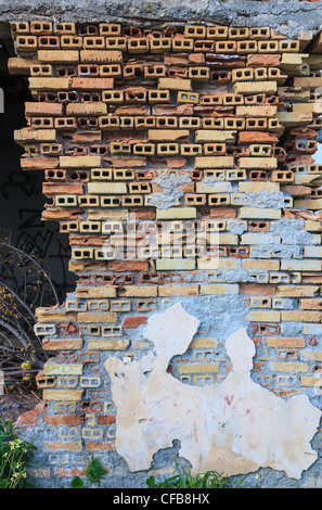 Vecchio abbandonato casa di mattoni resti in Grecia, rovinato un muro di mattoni dettaglio Foto Stock