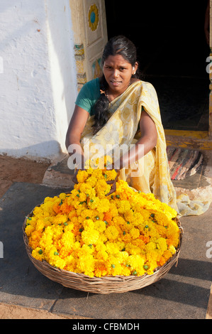 Giovane donna indiana con un cesto di fiori di tagete. Andhra Pradesh, India Foto Stock