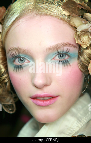 John Galliano Parigi Backstage Primavera Estate modello capelli oro rosa indossando le decorazioni blu turchese ombretto, rosa blusher, Foto Stock