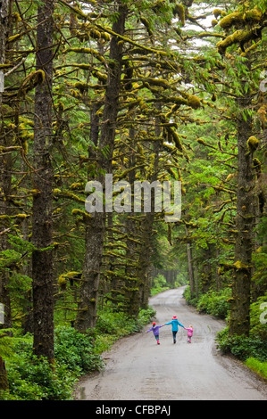 La madre e le sue due figlie sulla strada per il traino di collina, Naikoon Provincial Park, Queen Charlotte Islands, British Columbia, Canada Foto Stock