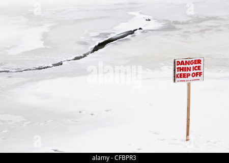 Pericolo ghiaccio sottile tenere fuori un cartello di segnalazione. Red River, Winnipeg, Manitoba, Canada. Foto Stock