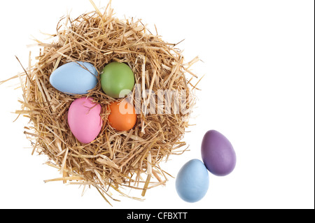 Nido di paglia con belle colorate le uova di Pasqua su bianco studio shoot Foto Stock