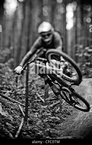 Giovane maschio mountain biker cattura aria sulla montagna di alci, Kananaskis AB Foto Stock