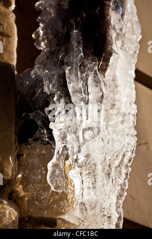 Il ghiaccio formato dal gocciolamento di acqua da una tubazione di scarico nel duro inverno a Vilnius, Lituania Foto Stock