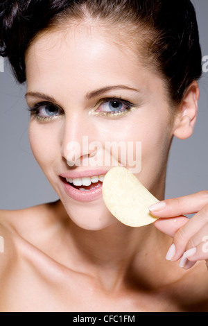 Femmina arricciata lunghi capelli neri segnato, in modo che i riccioli sedersi sulla cima della sua testa, indossando la luce rosa rossetto, metallica Foto Stock