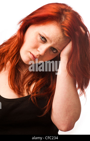 Un giovane i Capelli rossi ragazza adolescente donna che guarda triste lonely premuto verso il basso da solo preoccupato ansioso Foto Stock