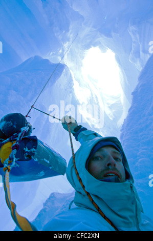 Uno sciatore che è caduto in un crepaccio mentre viaggia su un ghiacciaio nella gamma di Darwin, Cile, si trova in una situazione difficile Foto Stock