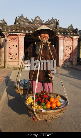Donna con ceste passando Chua Cau, ponte Giapponese, Hoi An, Annam, Vietnam Foto Stock