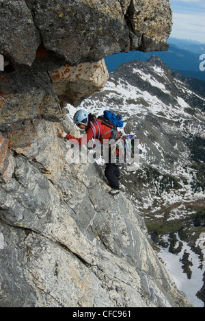 Una donna scalatore scala la parte superiore della cresta sud di Gimli, Valhalla Parco Provinciale, British Columbia, Canada Foto Stock