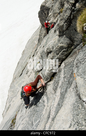 Due alpinisti affrontare l'imponente fronte sud di Asgard picco nel Valhalla montagne, Selkirk gamma, British Columbia, Canada Foto Stock