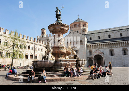 Gruppo di persone che si trovano in corrispondenza di una fontana nella piazza della città, cattedrale in background, Trento, Trentino, Italia, Europa Foto Stock
