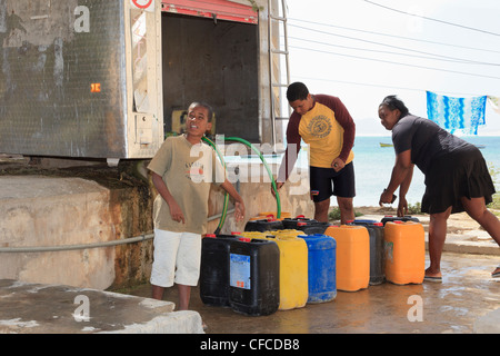 La popolazione locale con i contenitori per la raccolta di dissalata acqua fresca da bere da un bowser. Sal Rei Boa Vista Isole di Capo Verde. Foto Stock