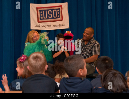 SANTA RITA, Guam (5 marzo 2012) Carmen Osbahr-Vertiz come Rosita e Kevin Clash come Elmo, si esibiscono con uno studente del CMdR. William C. McCool scuola elementare/media sulla base navale degli Stati Uniti Guam. Elmo e Rosita hanno visitato la scuola come parte di Talk, Listen, Connect, un'iniziativa educativa multifase progettata per aiutare i bambini attraverso spiegamenti, omaggi, lesioni correlate al combattimento e la morte di un genitore o di un amato che serve nell'esercito. Foto Stock