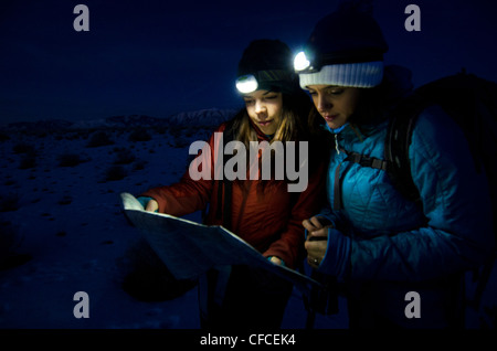 Due donne guardare su una mappa in la mattina presto prima di escursionismo in Sierra Foothills al di fuori del lago Tahoe, California. Foto Stock
