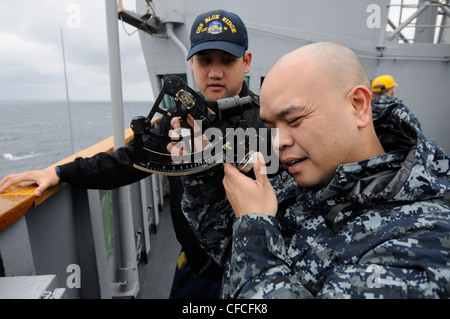 SEA OF JAPAN (5 marzo 2012) Quartermaster 1° Classe Howell Trinidad e J. g Keith Leung utilizzano un sestante a bordo della 7esima flotta statunitense USS Blue Ridge (LCC 19) per misurare l'approccio della nave durante un rifornimento verticale. Foto Stock