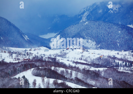 Incredibile paesaggio pittoresco in inverno prima di una tempesta ai piedi del Piatra Craiului massiccio, contea di Brasov, Romania. Foto Stock