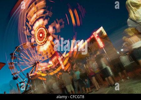 Le persone in attesa in linea presso il parco di divertimenti per ottenere sulle giostre Foto Stock