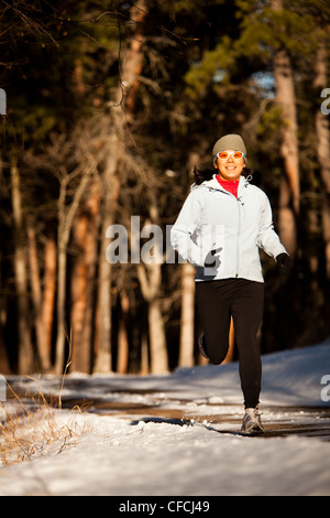 Una donna Japanese-American scorre in una radura di alberi lungo una strada sterrata nella luce della sera nel Custer State, South Dakota. Foto Stock