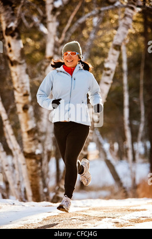 Una donna Japanese-American scorre in una radura di alberi lungo una strada sterrata nella luce della sera nel Custer State, South Dakota. Foto Stock