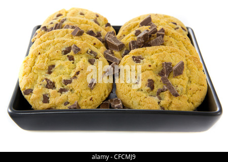 Una foto di due pile di alcuni biscotti al cioccolato con un po' di cioccolato su una piastra nera Foto Stock